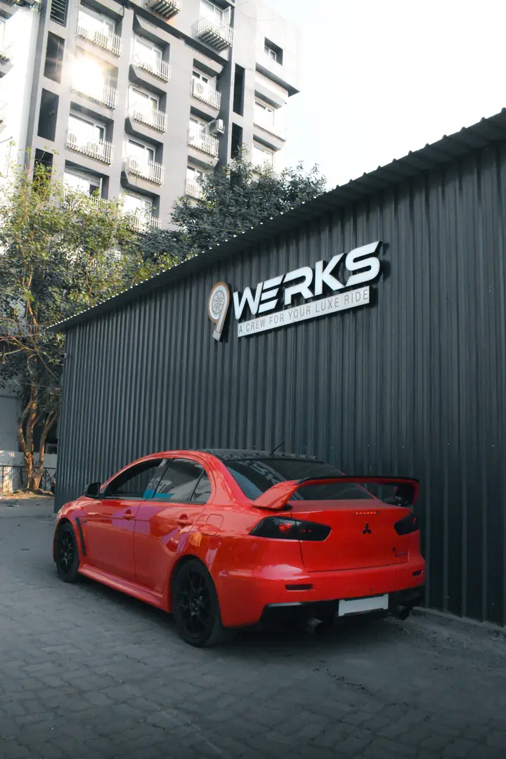 The 9WERKS workshop in Aundh with a red sports saloon parked outside